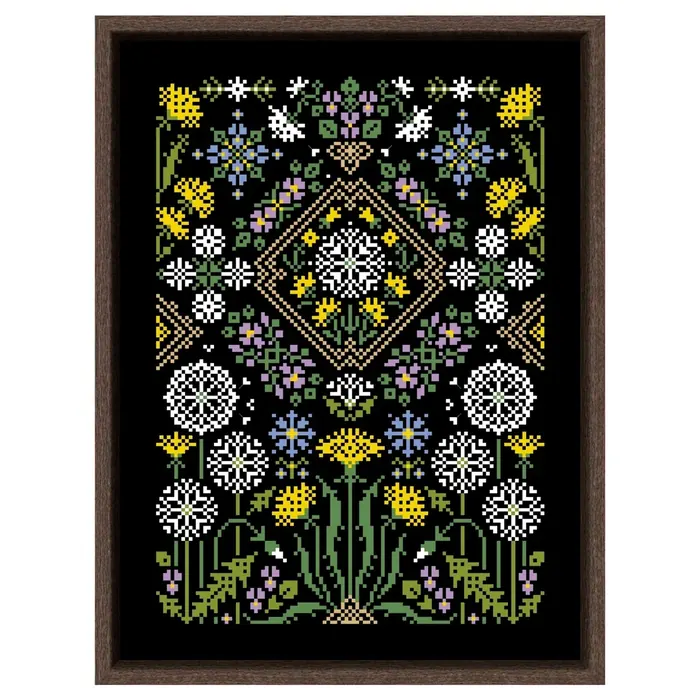The Dandelion black-canvas sampler framed in dark wood: yellow dandelions, white seed heads and blue cornflowers worked on black fabric