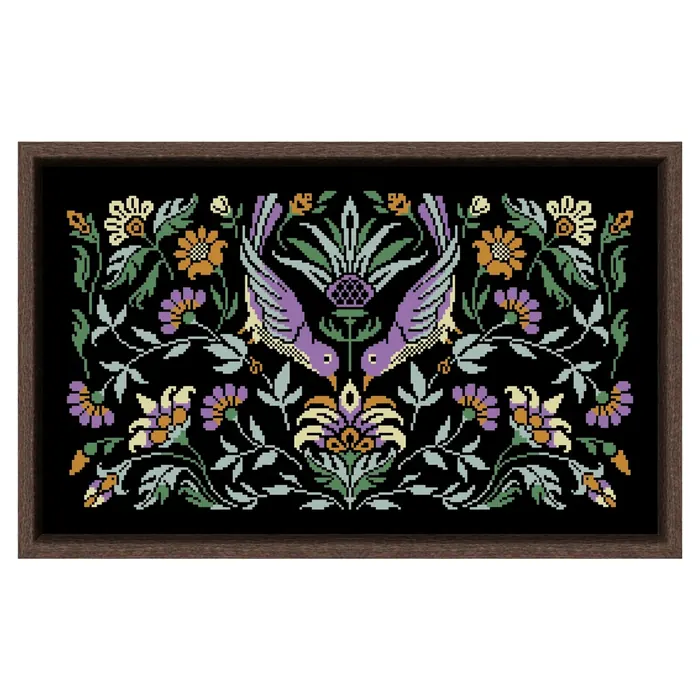 The Amethyst Bird Night Songs design framed in dark wood: two violet birds diving around a thistle with mauve and ochre flowers on black fabric