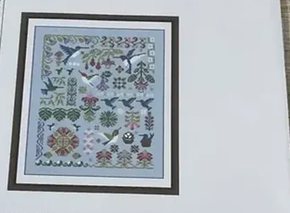 Buyer photo of the Hummingbird Geometry kit CC-K10-05: the printed design sheet with blue-green hummingbirds, pink fuchsias and border bands on sky-blue ground